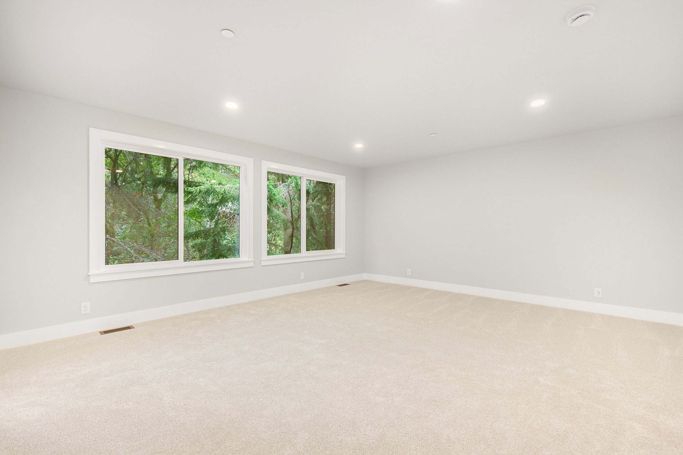 Spacious primary bedroom with large windows