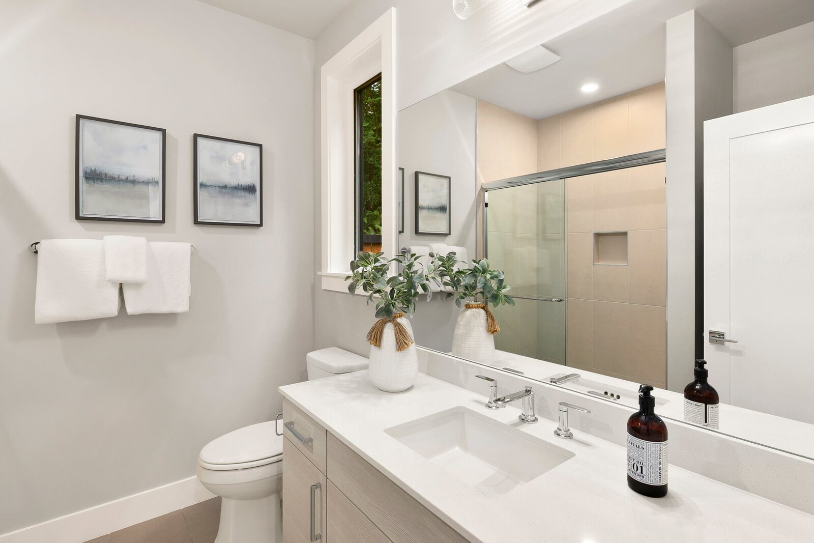Modern bath with streamlined vanity and glass-enclosed shower