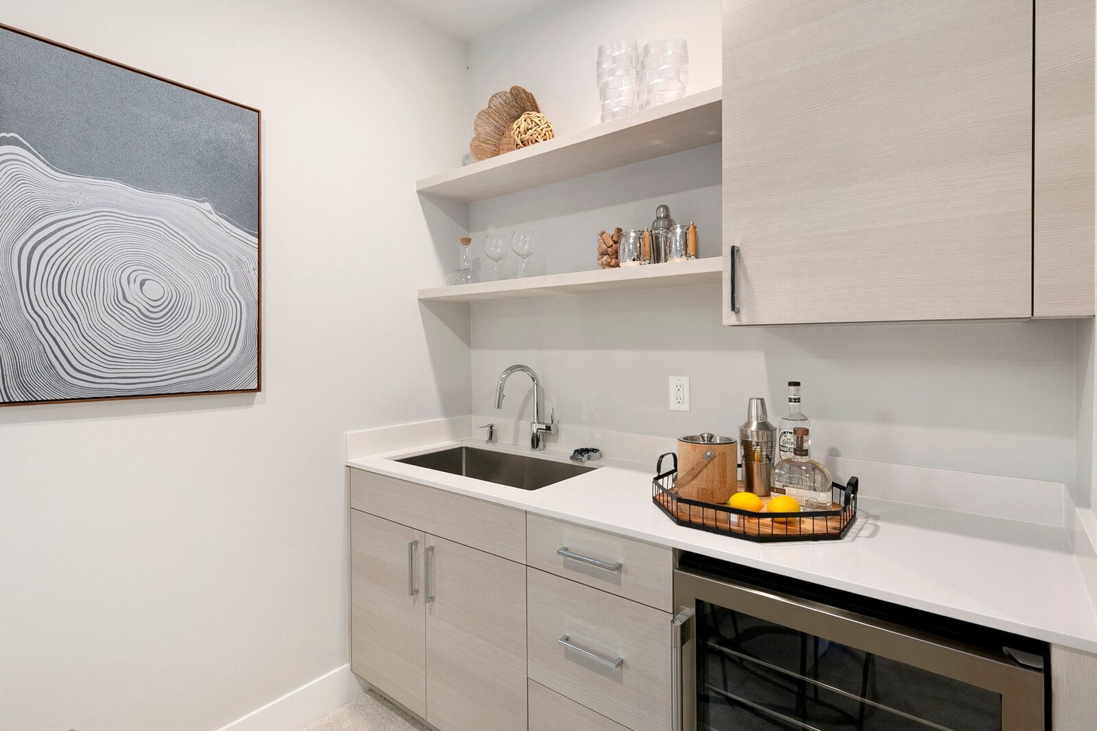 Stylish wet bar with sink, beverage cooler, and open shelving